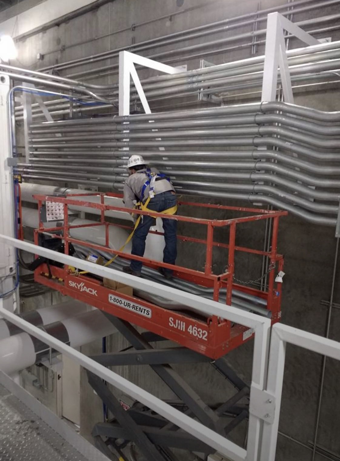 Electrician installing raceways from an elevated work platform